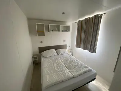 Ein Bett oder Betten in einem Zimmer der Unterkunft Mobilheim Jasmin mit Veranda am Kransburger See 554