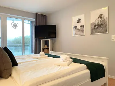 Ein Bett oder Betten in einem Zimmer der Unterkunft Haus Nordseebrandung FeWo C2.2