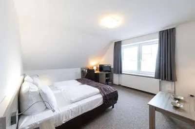 Ein Bett oder Betten in einem Zimmer der Unterkunft Cuxlandhotel Doppelzimmer 114