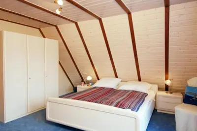Ein Bett oder Betten in einem Zimmer der Unterkunft 4 Personen Fachwerkhaus in erster Reihe zum Deich mit Badewanne und Kamin