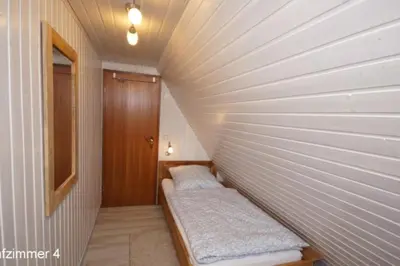 Ein Bett oder Betten in einem Zimmer der Unterkunft 6 Personen Ferienhaus mit 4 Schlafzimmern, Infrarotwaermekabine, mit Blick auf den Weltschiffahrtsweg in Otterndorf
