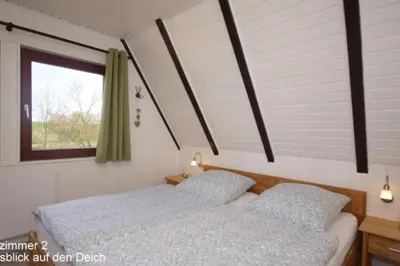 Ein Bett oder Betten in einem Zimmer der Unterkunft 6 Personen Ferienhaus mit 4 Schlafzimmern auf drei Etagen mit Blick auf den Weltschiffahrtsweg in Otterndorf