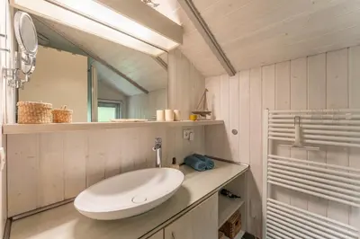Ein Badezimmer in der Unterkunft 4 Personen Luxusferienhaus mit Sauna, Kaminofen, Klimaanlage, Kanu und Seeblick in Otterndorf