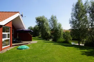 Ein Garten an der Unterkunft 4 Personen Ferienhaus mit privatem Bootsteg, direkte Seelage, Kanu, Sauna und Kaminofen in Otterndorf