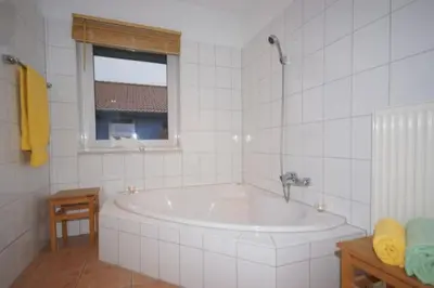 Ein Badezimmer in der Unterkunft 6 Personen Ferienhaus mit privatem Bootsteg, direkter Seelage, Kanu, Sauna und Badewanne in Otterndorf