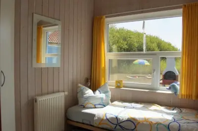 Ein Bett oder Betten in einem Zimmer der Unterkunft 6 Personen kinderfreundliches Ferienhaus mit Sauna, Whirlpool und Kaminofen in Otterndorf