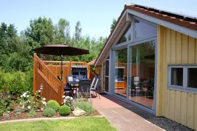 Ein Garten an der Unterkunft Kinderfreundliches 5 Personen Wellnessferienhaus Treibholz mit zwei Duschen und Toiletten, Sauna, Whirlpool, Kaminofen, Wintergarten und Kanu in Otterndorf
