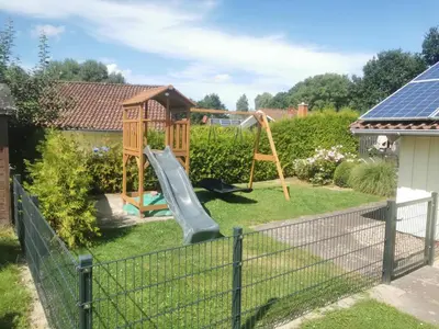 Ein Garten an der Unterkunft Kinderfreundliches 5 Personen Wellnessferienhaus Treibholz mit zwei Duschen und Toiletten, Sauna, Whirlpool, Kaminofen, Wintergarten und Kanu in Otterndorf