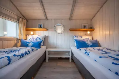 Ein Bett oder Betten in einem Zimmer der Unterkunft Kinderfreundliches 5 Personen Wellnessferienhaus Treibholz mit zwei Duschen und Toiletten, Sauna, Whirlpool, Kaminofen, Wintergarten und Kanu in Otterndorf