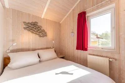 Ein Bett oder Betten in einem Zimmer der Unterkunft 12 Personen Familienferienhaus mit Sauna, Whirlpool, zwei Duschen und Toiletten, Kaminofen und Kanu in 1. Reihe zum See mit wundervollem Seeblick in Otterndorf