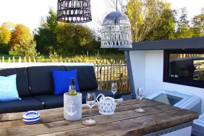 Ein Balkon oder eine Terrasse in der Unterkunft 8 Personen Hausboot mit Hot Tub, Sauna, Kaminofen, Klimaanlage, Lounge, Sonnendeck und Garten mit Buddelschiff direkt hinterm Deich in Otterndorf