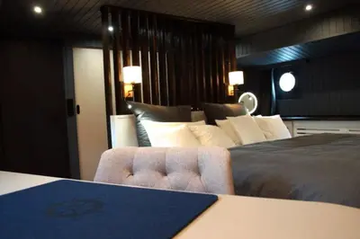 Ein Bett oder Betten in einem Zimmer der Unterkunft 8 Personen Hausboot mit Hot Tub, Sauna, Kaminofen, Klimaanlage, Lounge, Sonnendeck und Garten mit Buddelschiff direkt hinterm Deich in Otterndorf