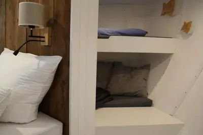 Ein Bett oder Betten in einem Zimmer der Unterkunft 8 Personen Hausboot mit Hot Tub, Sauna, Kaminofen, Klimaanlage, Lounge, Sonnendeck und Garten mit Buddelschiff direkt hinterm Deich in Otterndorf
