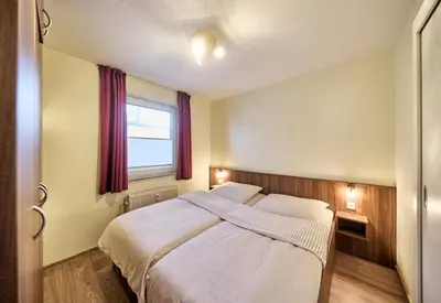 Ein Bett oder Betten in einem Zimmer der Unterkunft Dünenglück, Ferienwohnung 21
