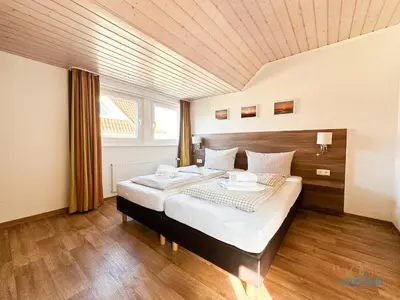 Ein Bett oder Betten in einem Zimmer der Unterkunft Familienurlaub auf zwei Ebenen im Herzen von Duhnen